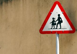 Two children in silhouette road crossing sign