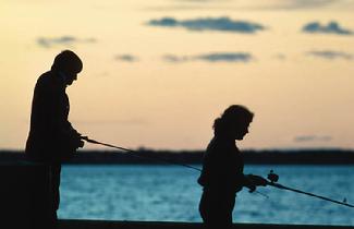 Two people in silhouette fishing